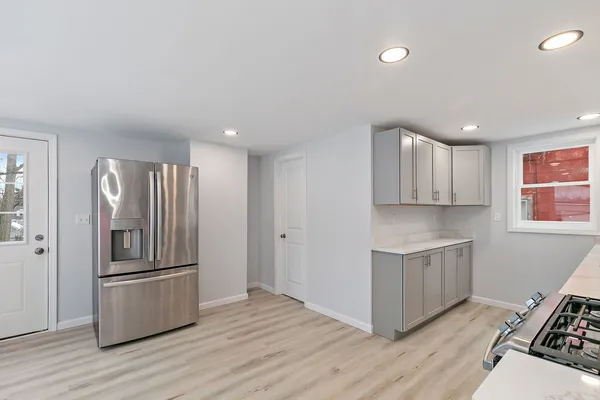 a kitchen with stainless steel appliances granite countertop a refrigerator and a stove top oven