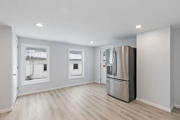 a view of a kitchen with wooden floor and refrigerator