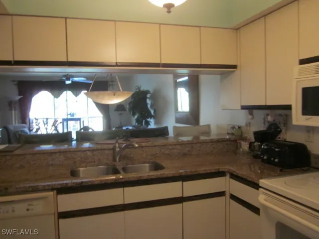 a kitchen with stainless steel appliances granite countertop a sink and a refrigerator