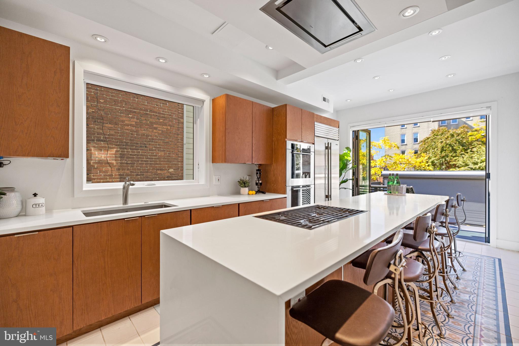 2530 13th Street Northwest Washington, DC 20009 - Photo 12 of 33 a kitchen with stainless steel appliances a table chairs and a refrigerator