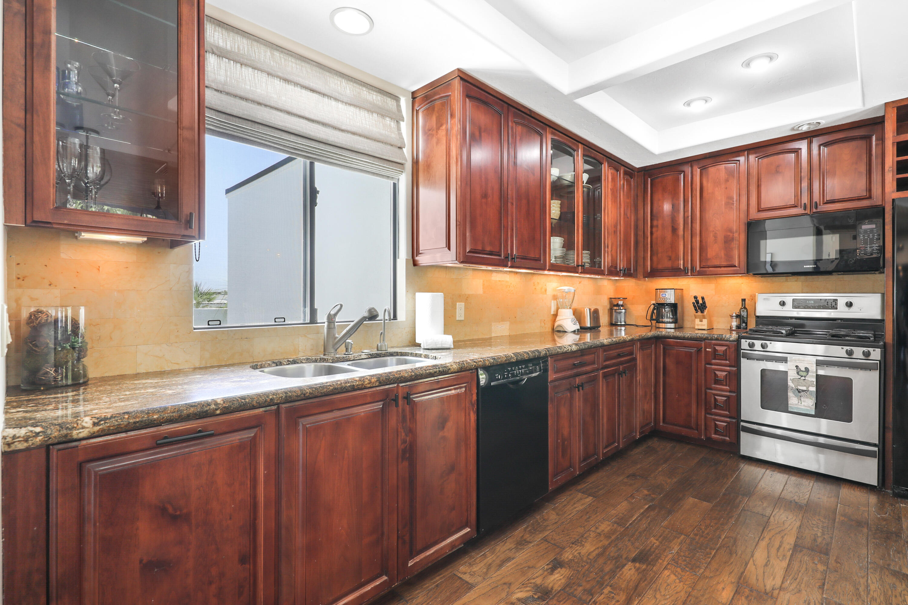 71345 Halgar Road Rancho Mirage, CA 92270 - Photo 10 of 32 a kitchen with stainless steel appliances granite countertop wooden cabinets a sink and dishwasher a stove with wooden floor