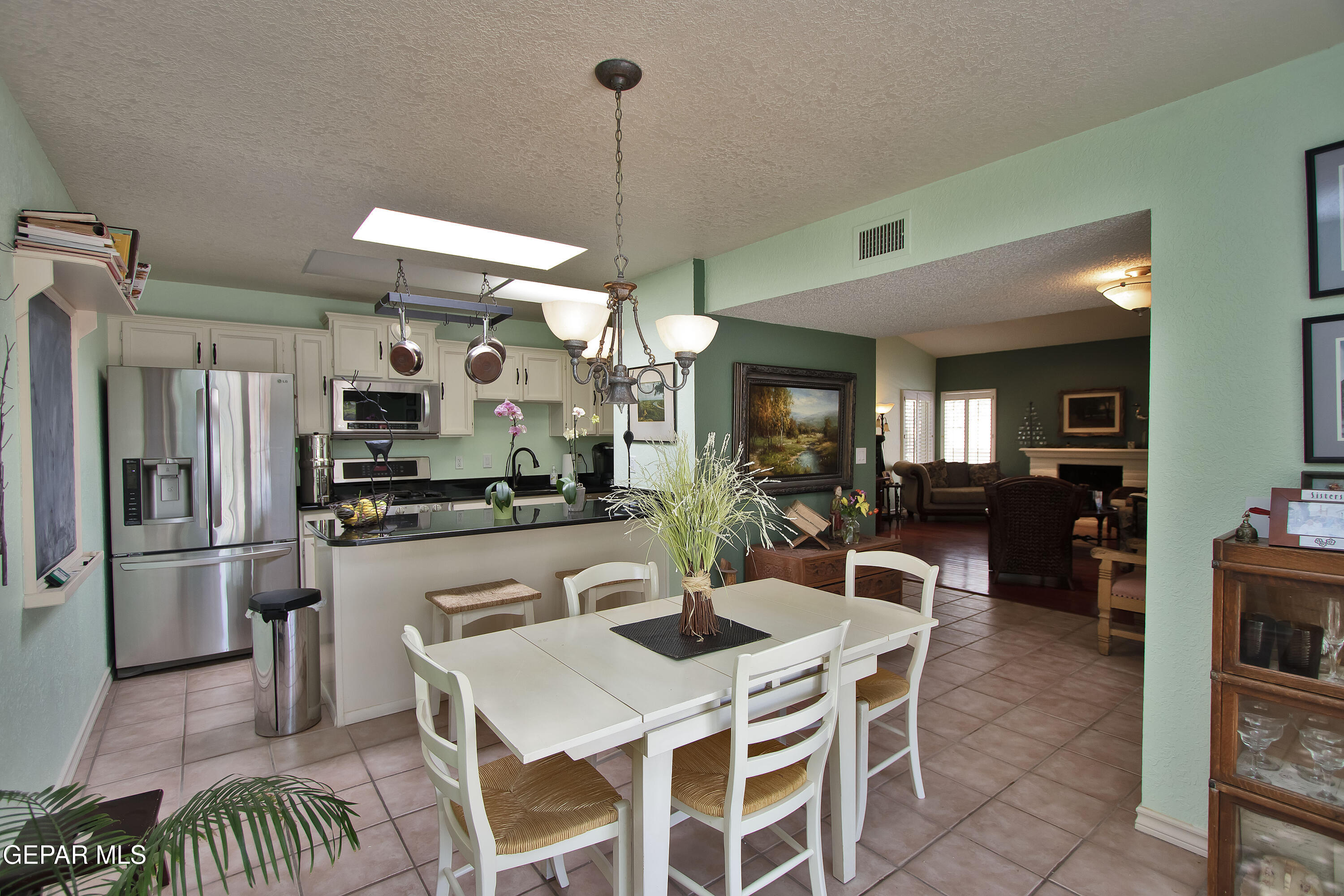 116 North Trevino Road Santa Teresa, NM 88008 - Photo 18 of 77 a kitchen with stainless steel appliances kitchen island granite countertop a refrigerator a stove a sink a dining table and chairs with wooden floor