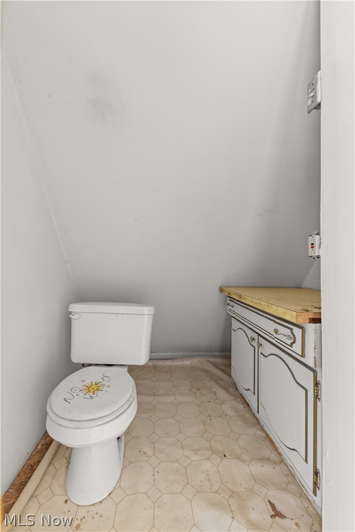409 Edith Avenue Akron, OH 44312 - Photo 42 of 45 Compact space featuring a commode and a built-in base cabinet with a light-toned countertop