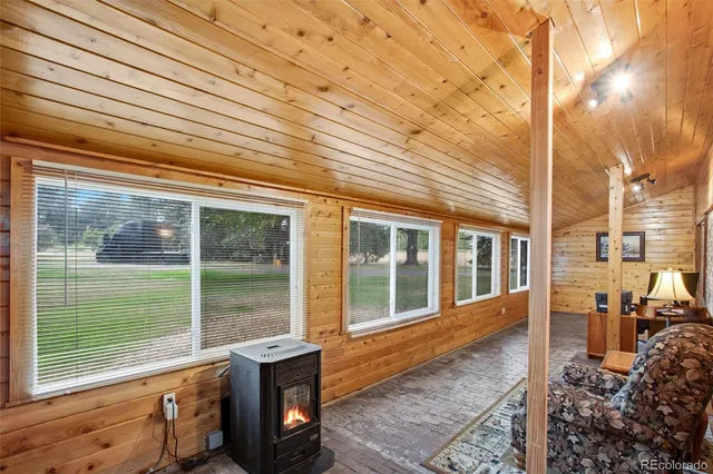 a view of patio with table and chairs under an umbrella with wooden floor