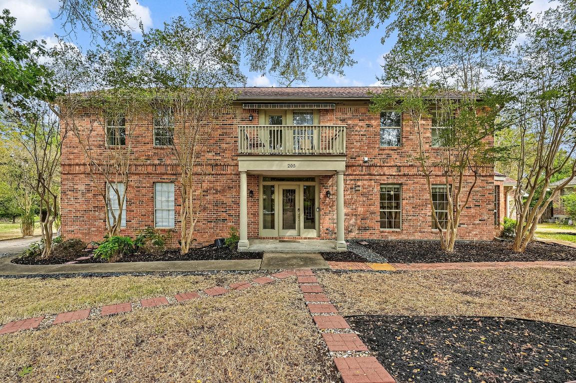 front view of a brick house with a yard