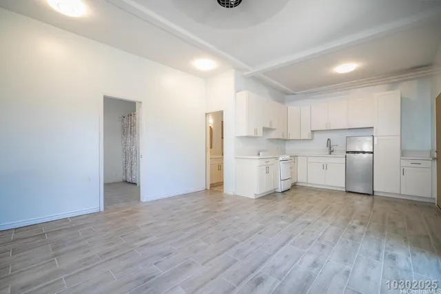 a view of a kitchen with a sink and a refrigerator