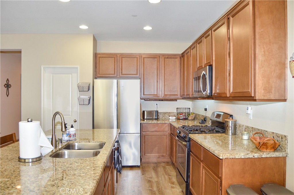166 Fox Lane Calimesa, CA 92320 - Photo 19 of 76 This Kitchen is a Great Place to Gather with Granite-topped Counters, Island Seating, Stainless Steel Appliances, a Coffee Bar, and a Walk-in Pantry - All Open to the Living Area, Dining Room, and Back Patio