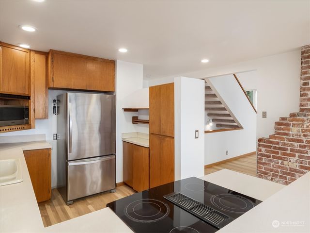 a kitchen with stainless steel appliances granite countertop a refrigerator and a stove top oven