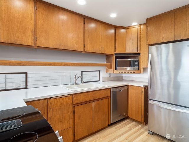 a kitchen with stainless steel appliances granite countertop a refrigerator a sink dishwasher with a stove and cabinets