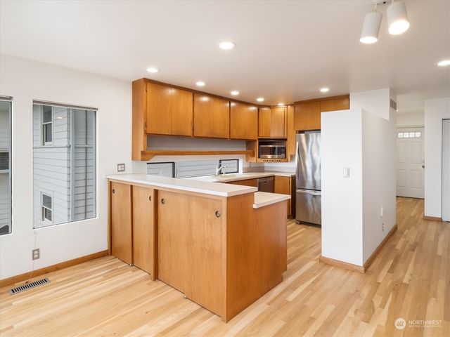 a kitchen with stainless steel appliances granite countertop a refrigerator sink and white cabinets