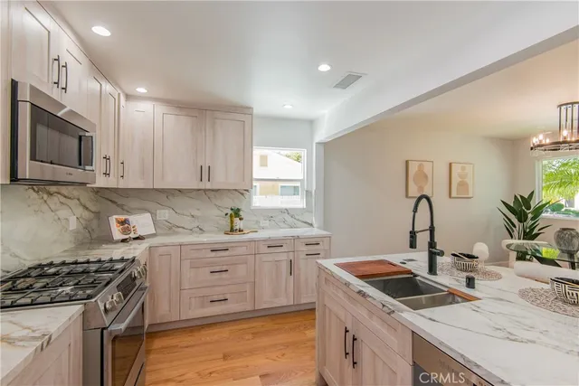 a kitchen with granite countertop a sink stainless steel appliances and cabinets