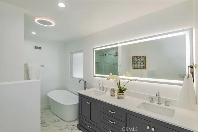 a bathroom with a toilet sink double vanity and mirror
