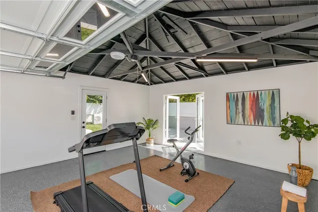 a room with gym equipment and wooden floor