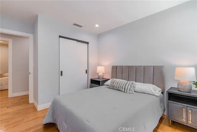 a bedroom with a bed and wooden floor