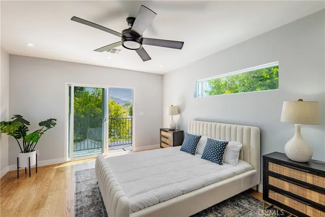 a bedroom with a bed chandelier and a window
