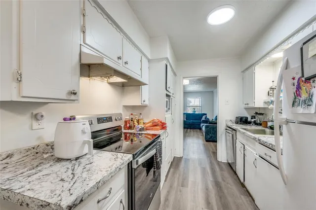 a kitchen with granite countertop lots of counter top space stove and wooden floor
