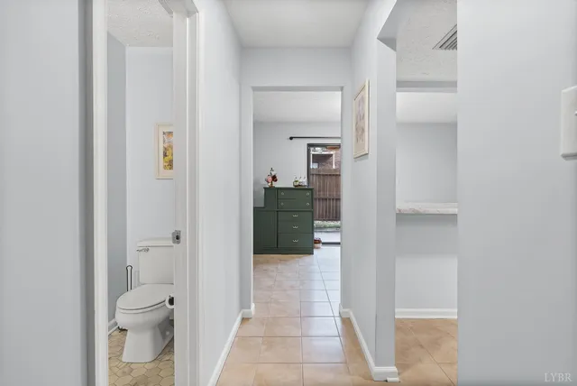 a bathroom with a granite countertop toilet and a view of bathroom