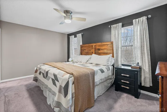 a bedroom with a bed a dresser and a window