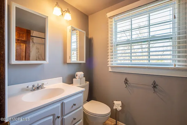 a bathroom with a sink a toilet and window