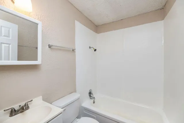 a bathroom with a sink toilet and mirror