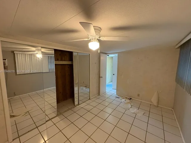 an empty room with closet and windows