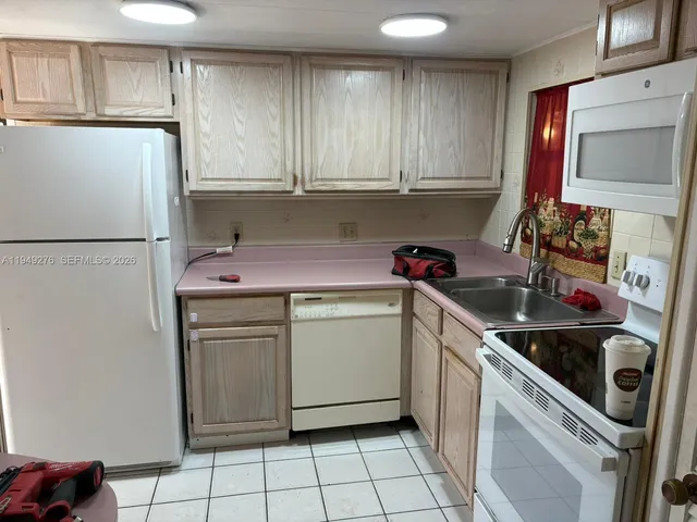 a kitchen with a stove sink and cabinets