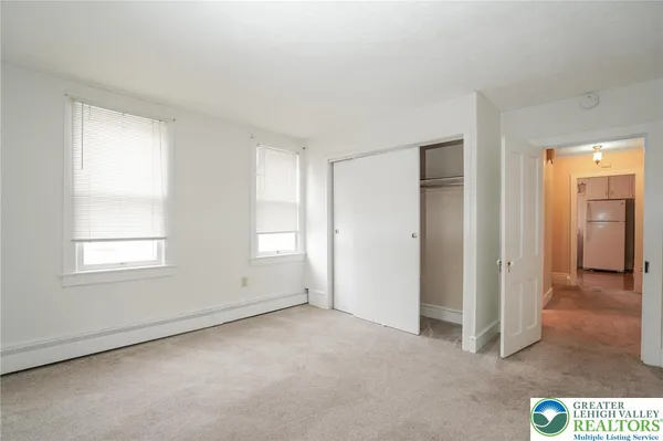 an empty room with windows and closet