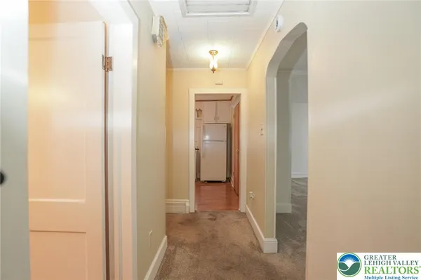 a view of a hallway with wooden shelves