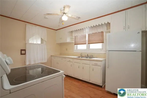 a kitchen with a sink a refrigerator and cabinets