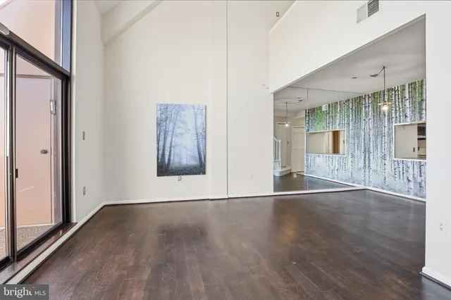 an empty room with wooden floor fireplace and cabinet