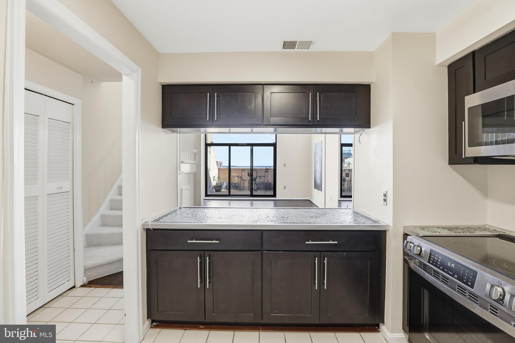1301 North Courthouse Road, Unit 1804 Arlington, VA 22201 - Photo 15 of 29 a kitchen with stainless steel appliances a sink and a microwave
