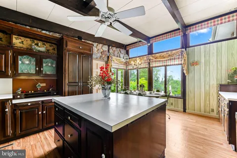 a view of a dining room with furniture a kitchen and chandelier