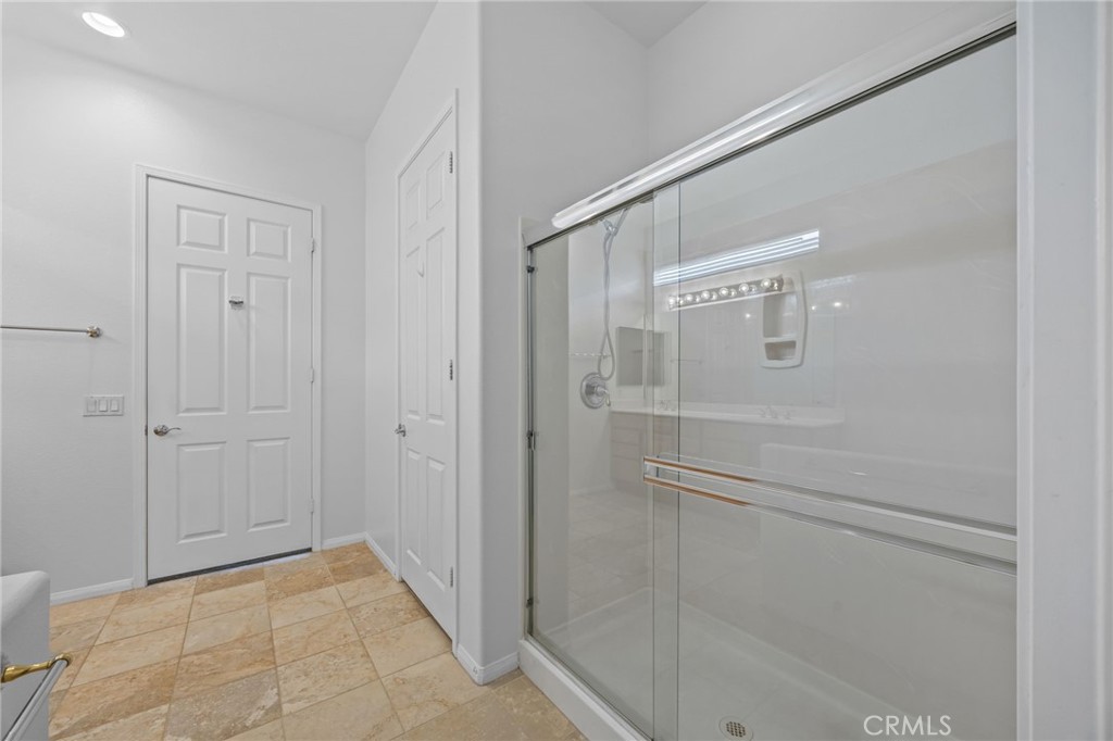 1140 Lantana Road Beaumont, CA 92223 - Photo 18 of 30 a bathroom with a glass shower door
