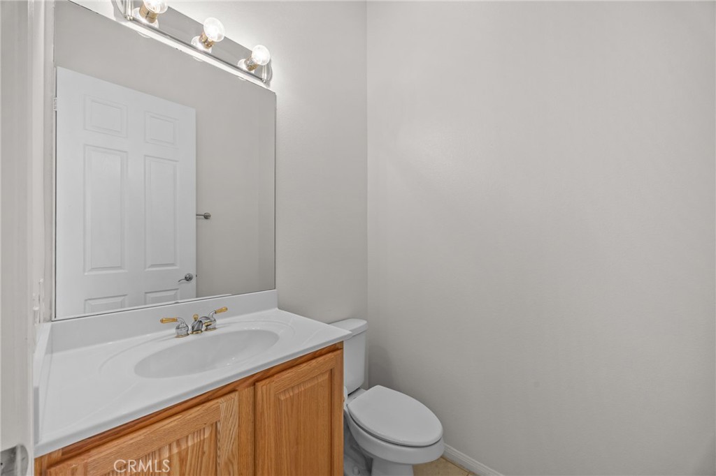 1140 Lantana Road Beaumont, CA 92223 - Photo 25 of 30 a bathroom with a granite countertop sink toilet and a mirror