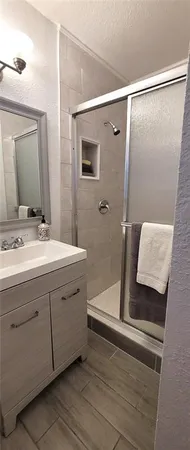 a bathroom with a double vanity sink and mirror with shower