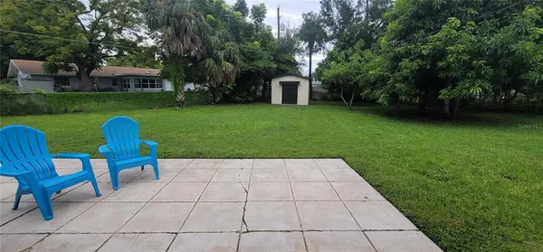 a view of backyard with seating area and green space