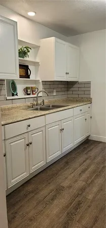 a kitchen with sink cabinets and wooden floor