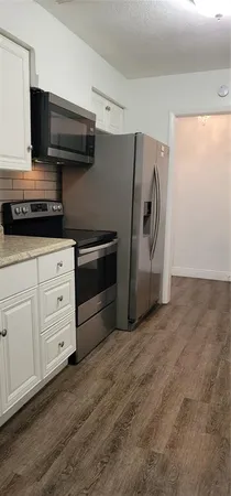 a kitchen with stainless steel appliances white cabinets and a refrigerator