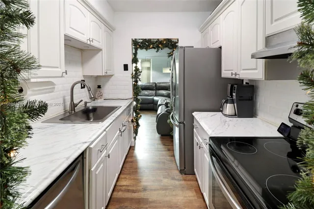 a kitchen with stainless steel appliances granite countertop a sink stove and refrigerator