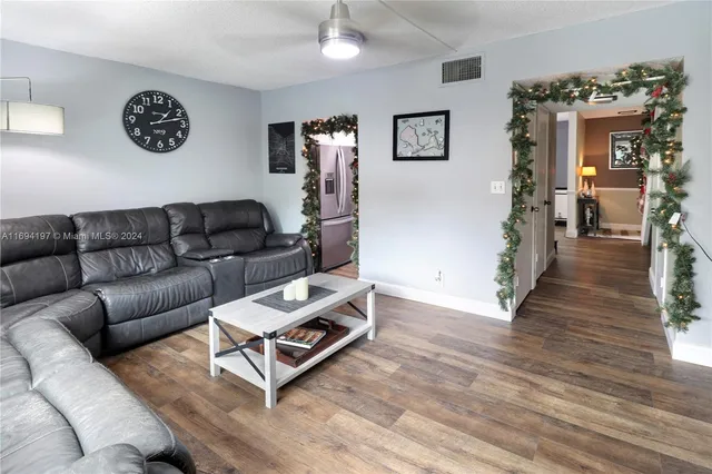 a living room with furniture and a wooden floor