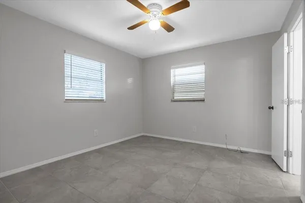 an empty room with windows and fan