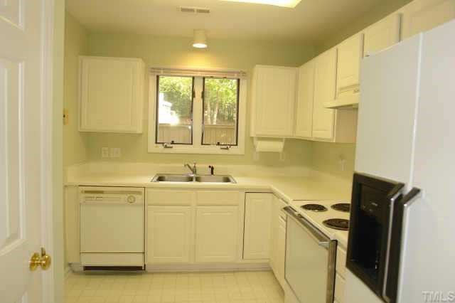 4211 Sunshadow Lane Raleigh, NC 27613 - Photo 4 of 10 a view of a kitchen with white cabinets