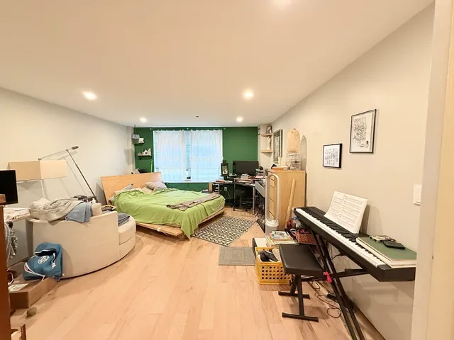 a bedroom with a bed and wooden floor