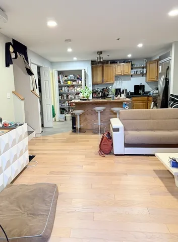 a living room with stainless steel appliances kitchen island granite countertop furniture and a view of kitchen