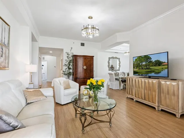 a living room with furniture a chandelier and a flat screen tv