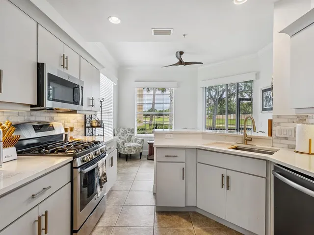 a kitchen with stainless steel appliances a stove sink microwave and cabinets