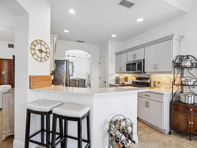 a kitchen with stainless steel appliances a table chairs and a refrigerator