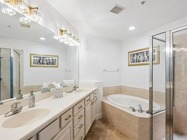 a bathroom with a tub a sink and mirror