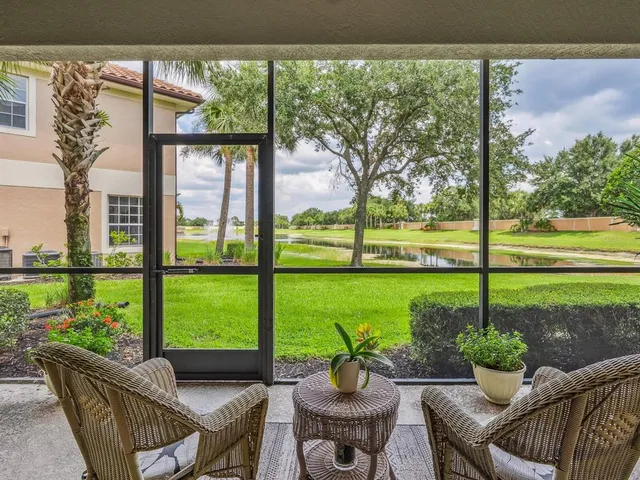 a living room with patio furniture and a garden
