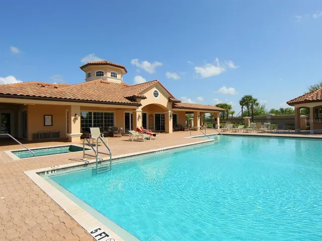 a view of swimming pool with outdoor seating and a garden
